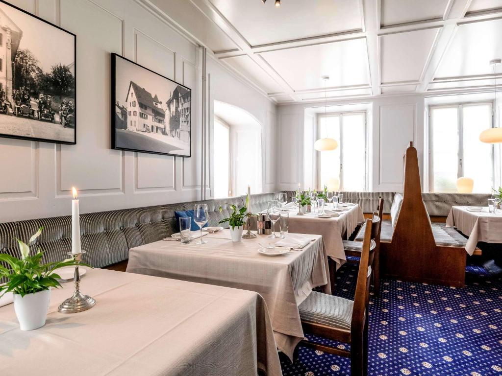 伦茨堡伦茨堡皇冠美居酒店的餐厅设有4张桌子和白色桌布