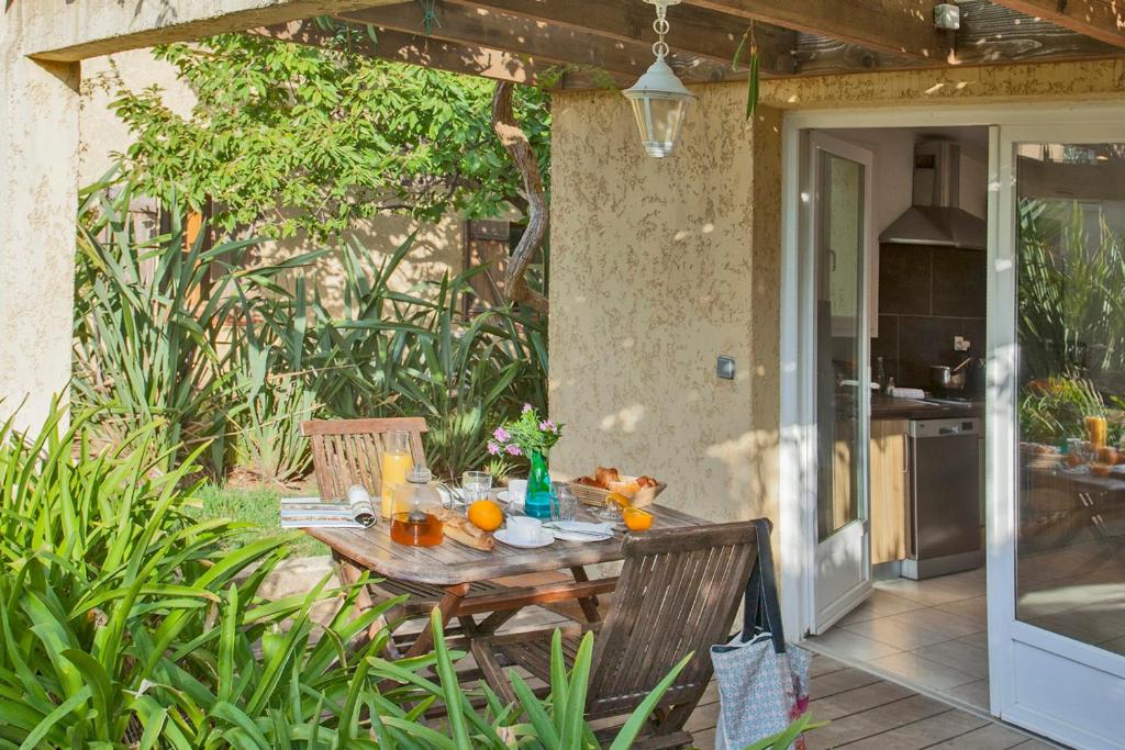 卡尔维minivilla lilas indépendante à Calvi avec jardin et piscine jardin et bbq的庭院里一张带橙子的木桌