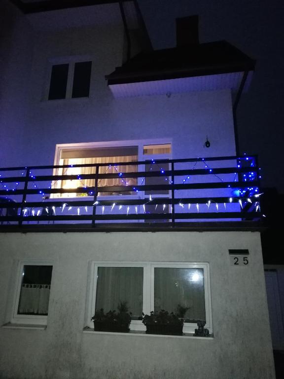 科沃布热格Apartament szafirowa25 pietro1的建筑一侧的阳台,配有蓝色的灯光