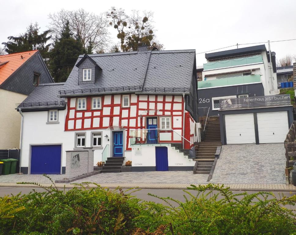 HübingenHübingen Cottage的一间红色和白色的房子,设有车库