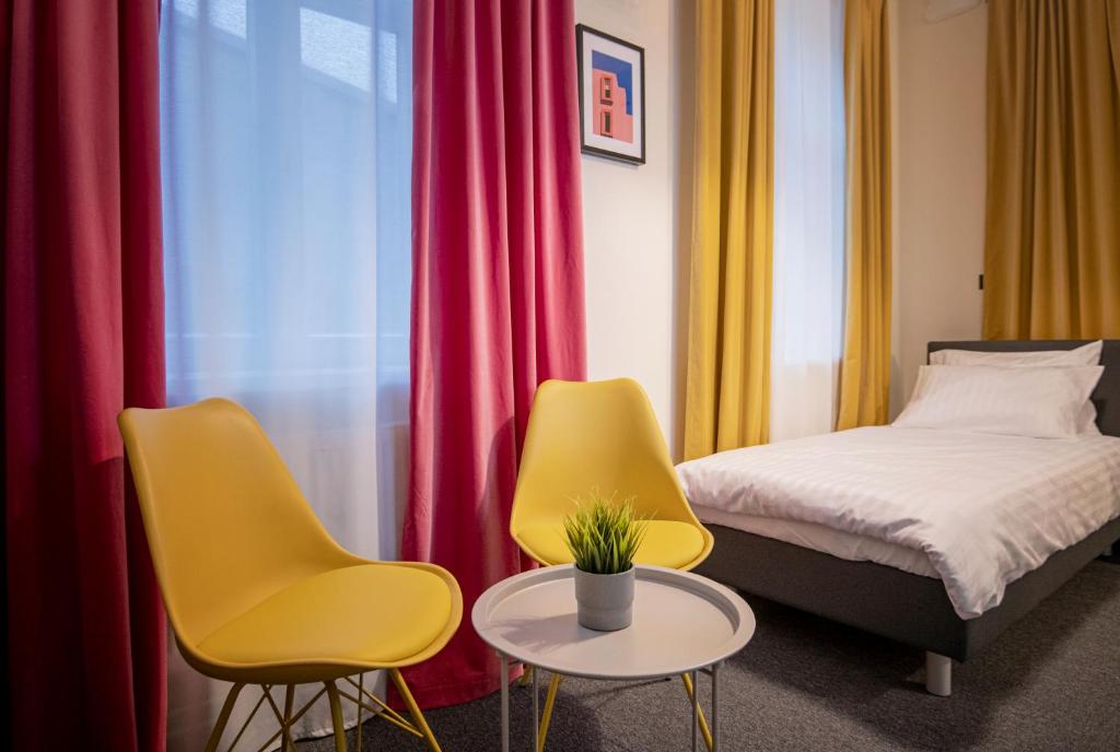 叶卡布皮尔斯RUMI Hotel with Self Check-In的一间卧室配有两把椅子、一张床和一张桌子