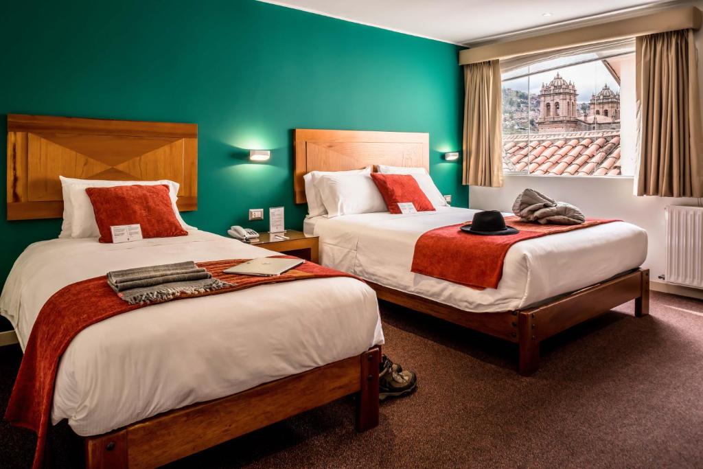 库斯科梅塔克瓦辛精品酒店的酒店客房设有两张床和窗户。