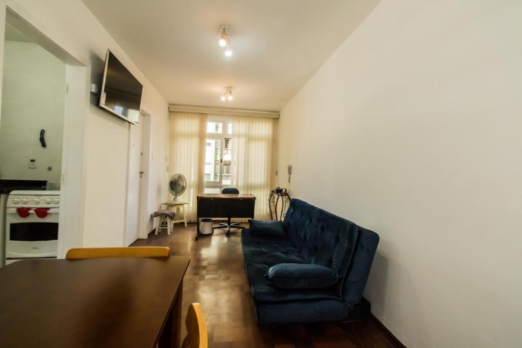 圣保罗Apartamento aconchegante com estacionamento na 25 de março的客厅配有蓝色椅子和桌子