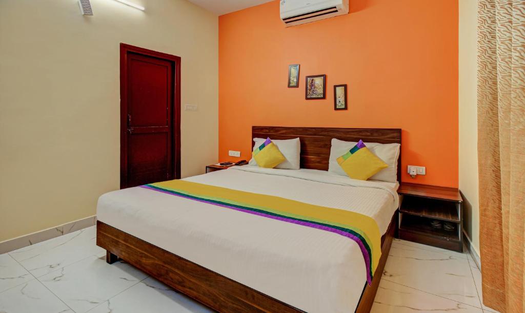 戈勒克布尔Itsy By Treebo - Royal Monarch的一间卧室配有一张带橙色墙壁的大床