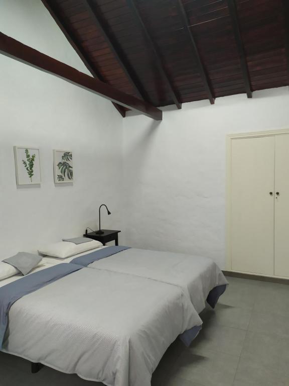 摩亚Moya, Senderos y naturaleza的白色卧室配有两张床和一张桌子