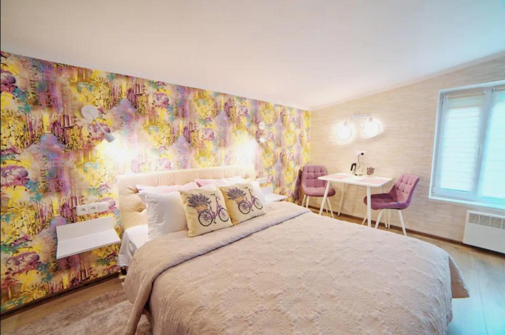 白采尔科维Затишні апартаменти Bed&Bike的一间卧室设有一张大床和色彩缤纷的墙壁