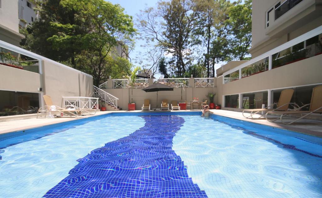 圣保罗伊兹艾克里米查奥酒店的一座大型蓝色游泳池,位于一座建筑中