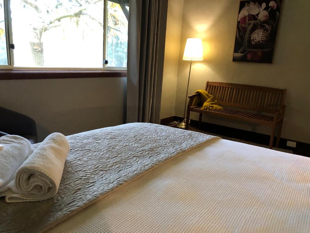 曼吉马普三叶草小屋乡村度假酒店的一间卧室配有带毛巾的床