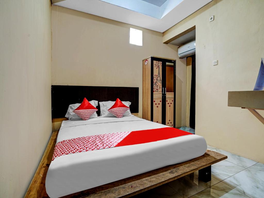 CikampekOYO Capital O 90081 Pondok Sabaraya 2 Syariah的一间卧室配有一张带红色枕头的大床