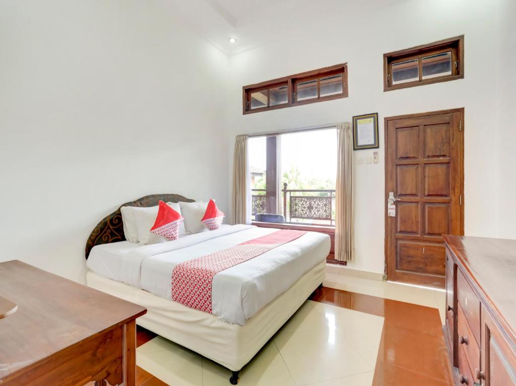 登巴萨SUPER OYO 3261 Hotel Ratu的一间卧室设有一张大床和一个窗户。