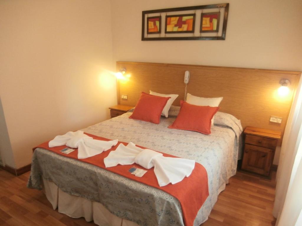 马德普拉塔Hotel Alma di Mare的一间卧室配有一张带红色枕头的大床