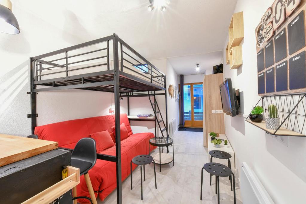 科特雷Studio idéalement situé的客房设有双层床和红色沙发。