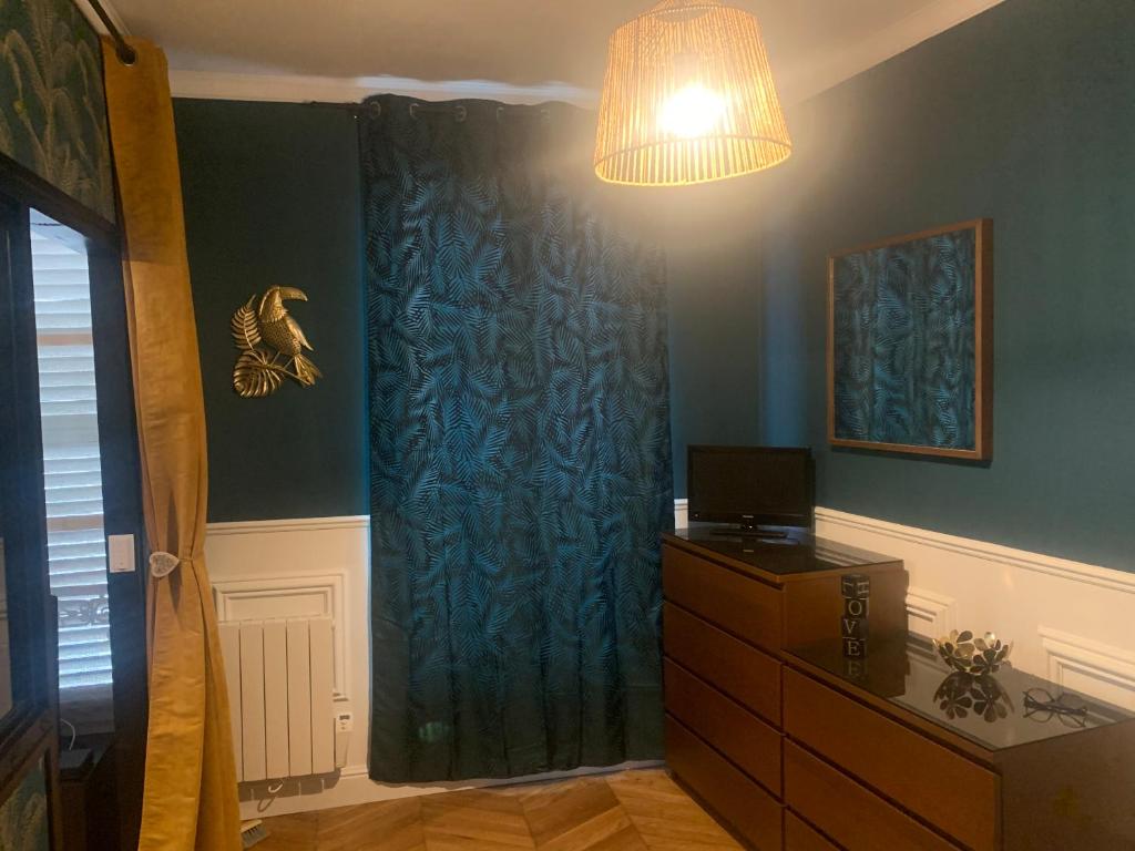 枫丹白露Appartement centre Fontainebleau的一间设有蓝色窗帘和梳妆台的房间