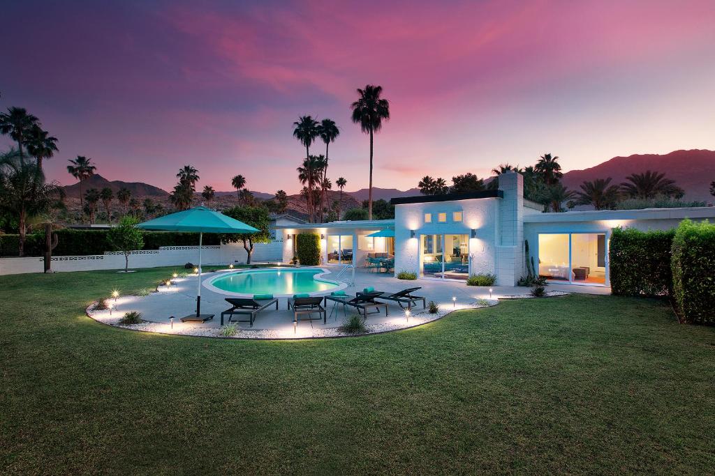 棕榈泉Casa Agave Palm Springs的一座晚上设有游泳池的房子