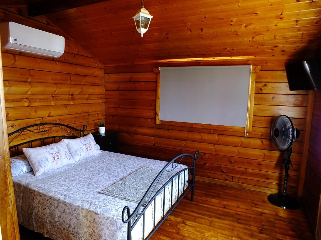 吉亚德伊索拉La Cabaña的小木屋内一间卧室,配有一张床