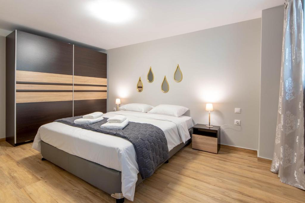 亚历山德鲁波利斯Amaryllis Maison Hili的一间卧室配有一张带白色床单的大床