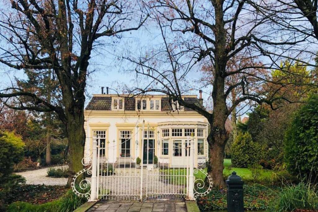 多德雷赫特Tiny house in tuin van de statige villa Mariahof的前面有栅栏的白色房子