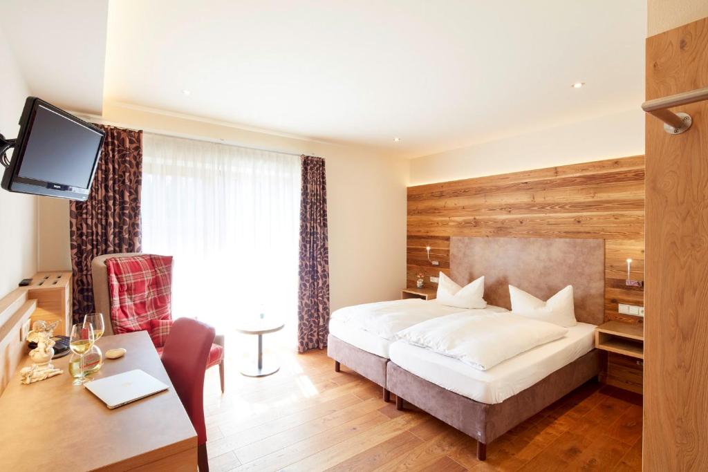 Dietersheim兰格斯霍夫菲德勒酒店的酒店客房配有一张床、一张书桌和一台电视。