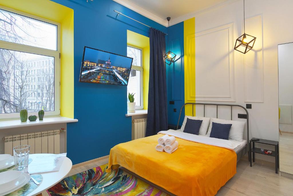 莫斯科Axis.Moscow Island的蓝色和黄色的卧室,配有床和桌子