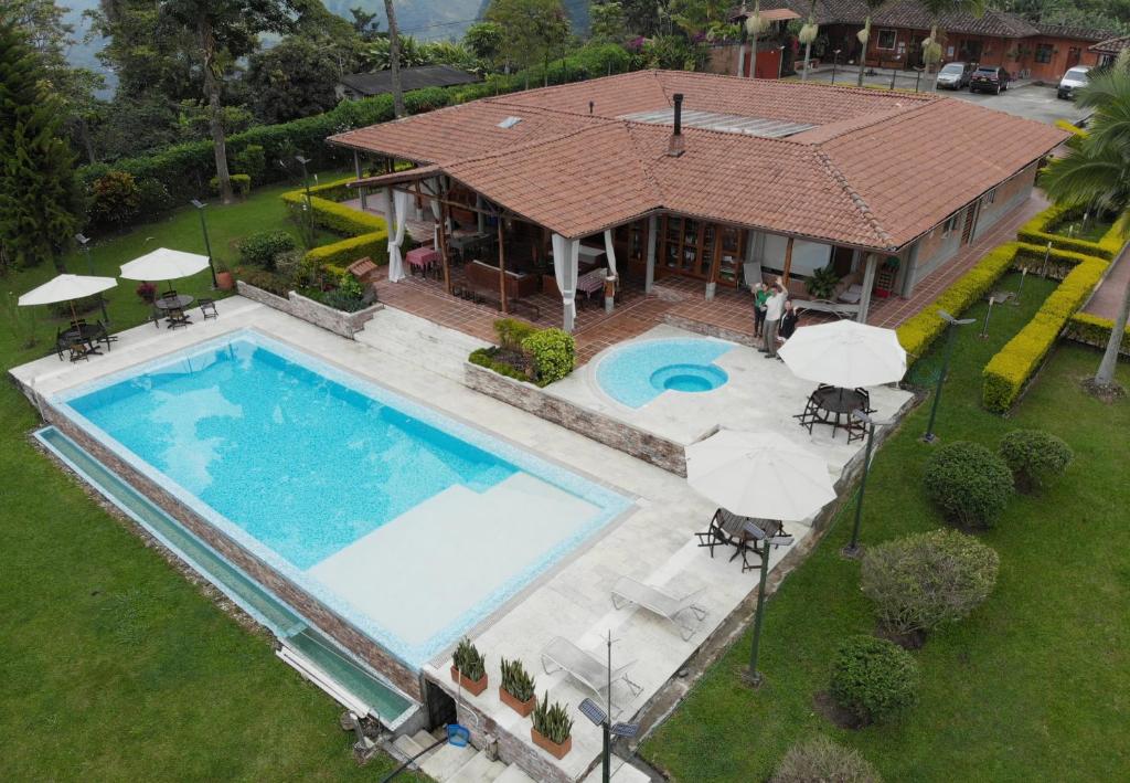 圣罗莎德卡瓦尔Hotel Finca Del Café的享有带游泳池的房屋的空中景致