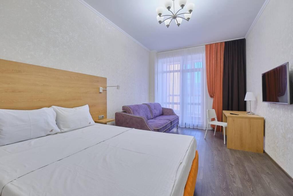 托木斯克Апартаменты Петровские однокомнатные Трифонова 22的酒店客房设有一张大床和一张沙发。