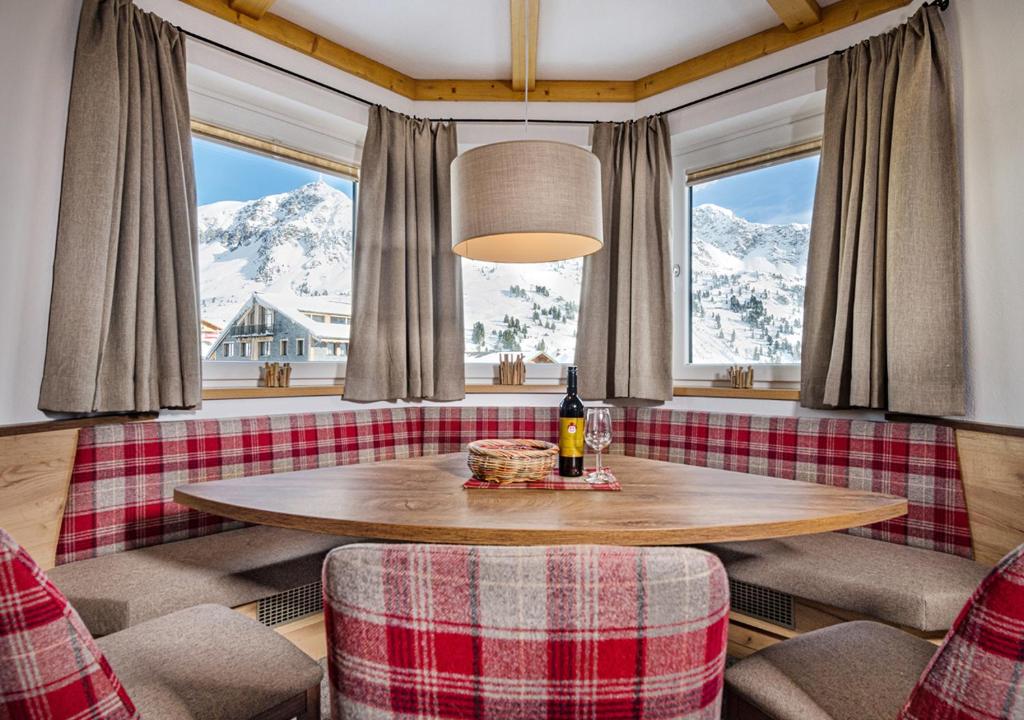 上陶恩Apartments & Garni Alpenrose的客房内的一张桌子享有雪覆盖的山脉美景