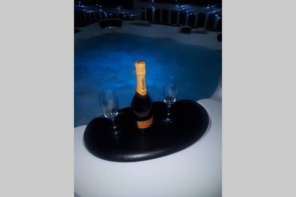 GarvockHillingworth's Hot Tub Retreat - St Cyrus的一瓶香槟和一张桌子上的两杯酒