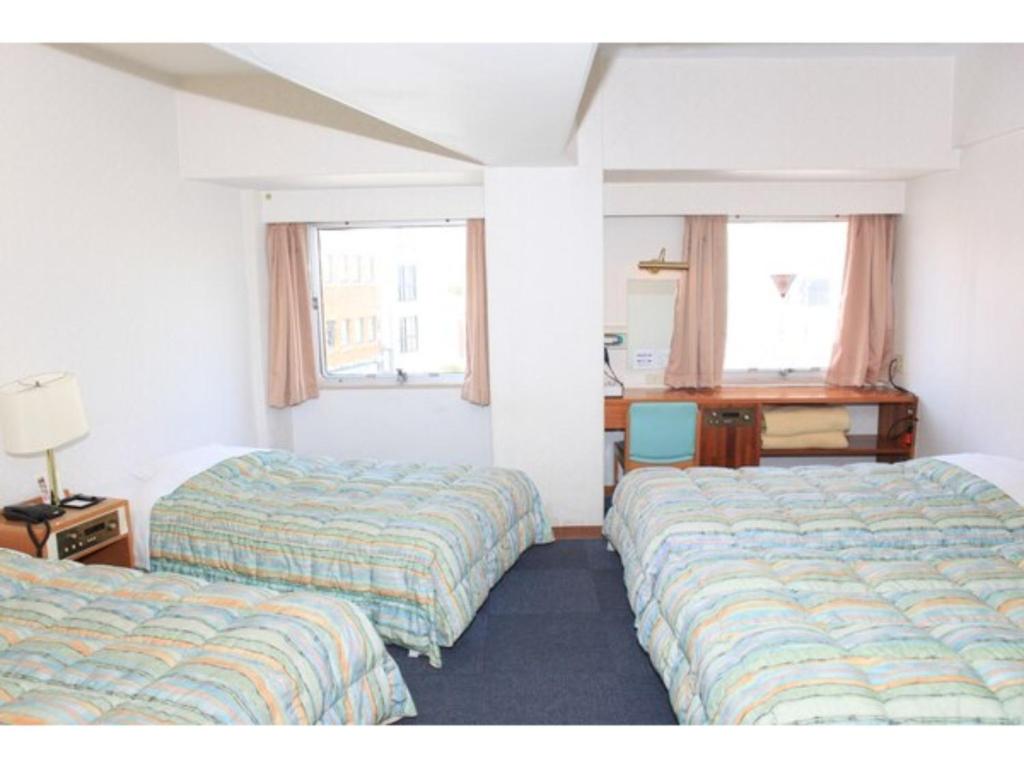 那霸Hotel Kokusai Plaza - Vacation STAY 09932v的酒店客房配有两张床和一张书桌