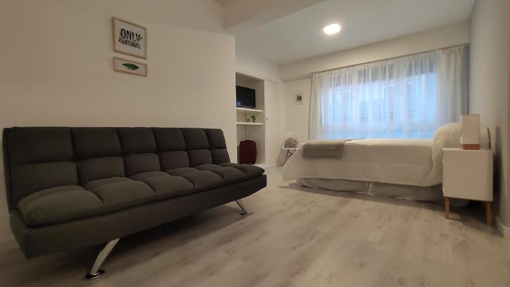 马德普拉塔Departamento centro mdp calle belgrano的客厅配有沙发和1张床