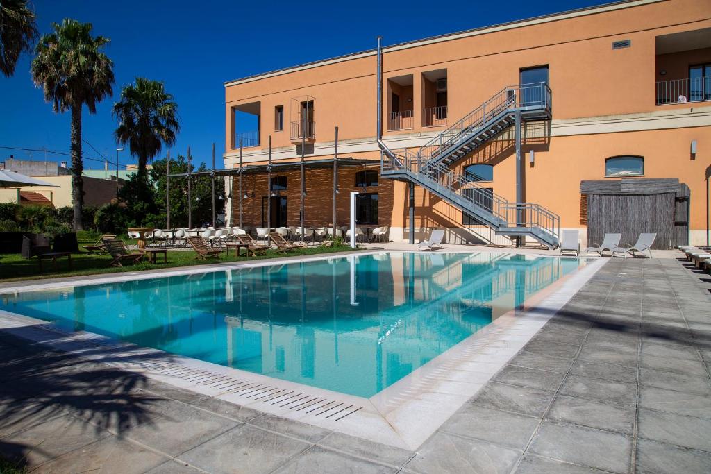 加利亚诺德尔卡波Il Tabacchificio Hotel的大楼前的游泳池