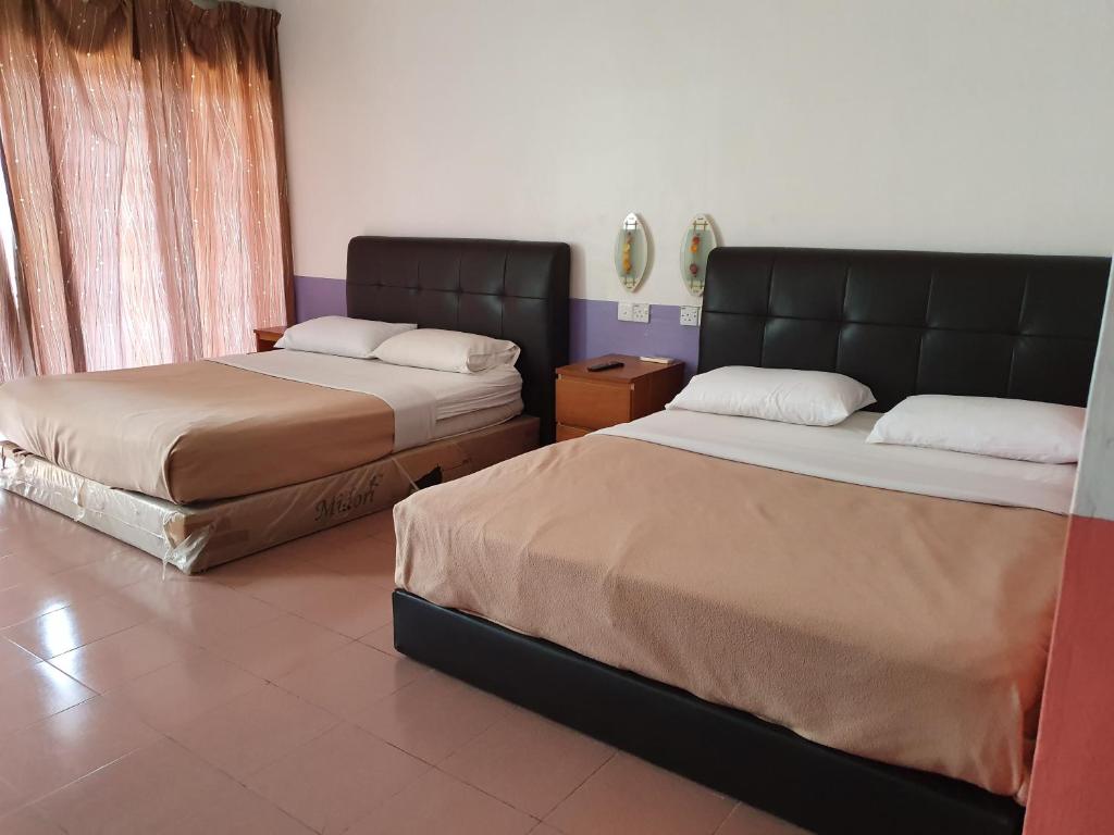 瓜拉丁加奴十星酒店的配有两张床垫的客房内的两张床