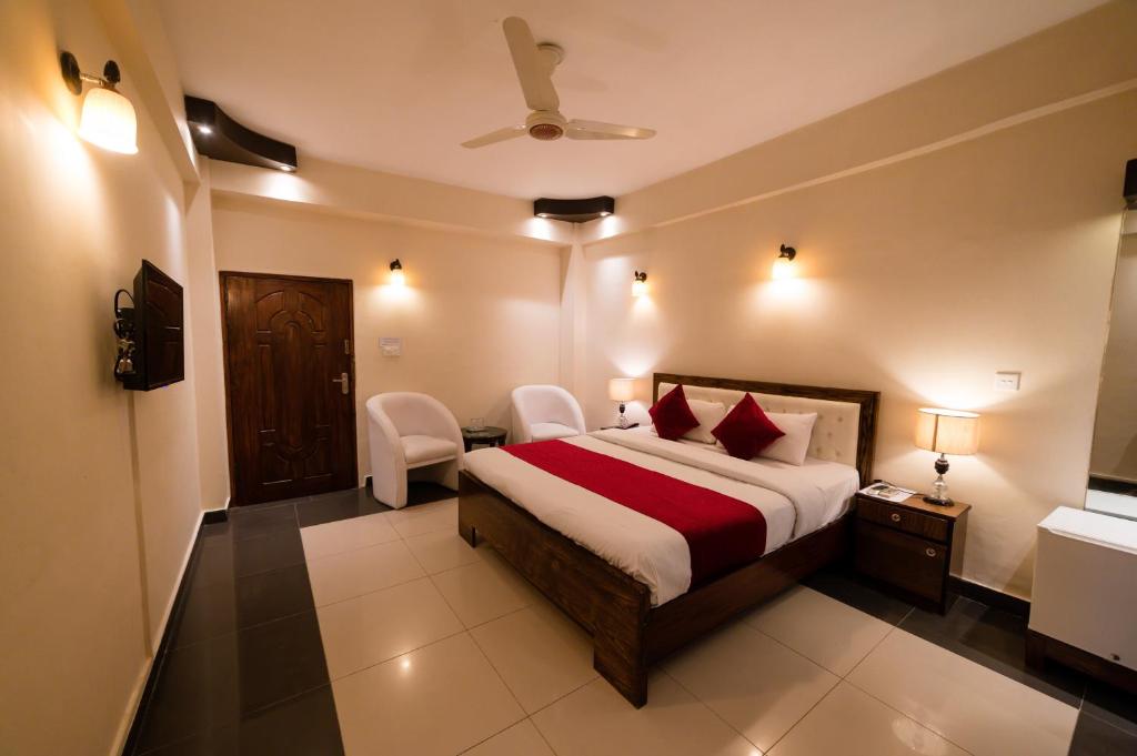 伊斯兰堡Laraib Inn Hotel的酒店客房配有一张床、一把椅子和一台电视。