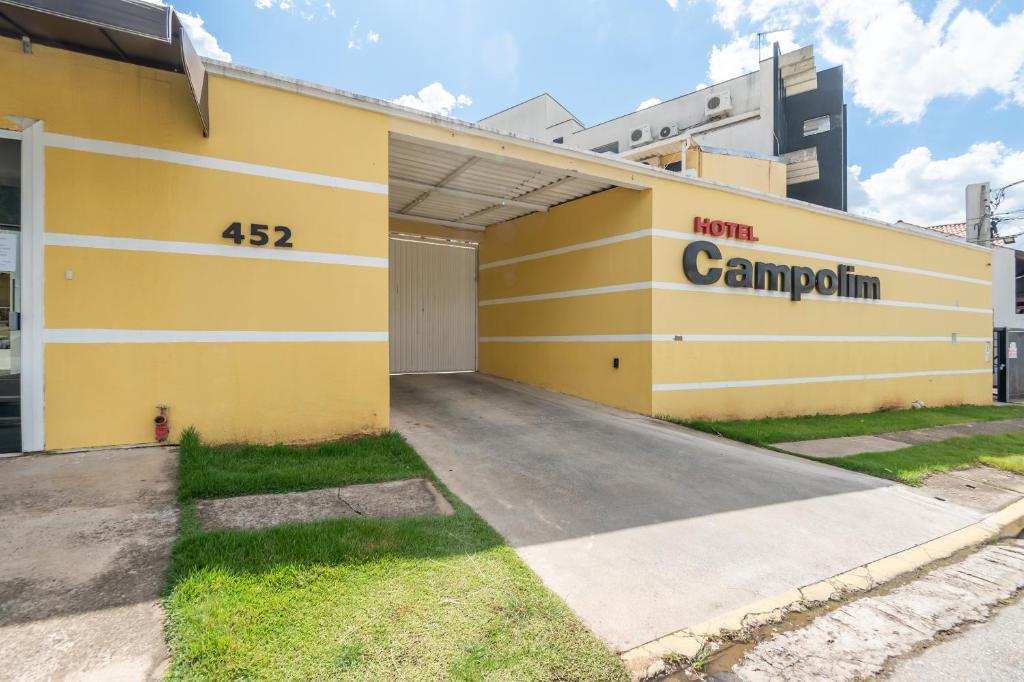 索罗卡巴Hotel Campolim的黄色的建筑,旁边标有标志