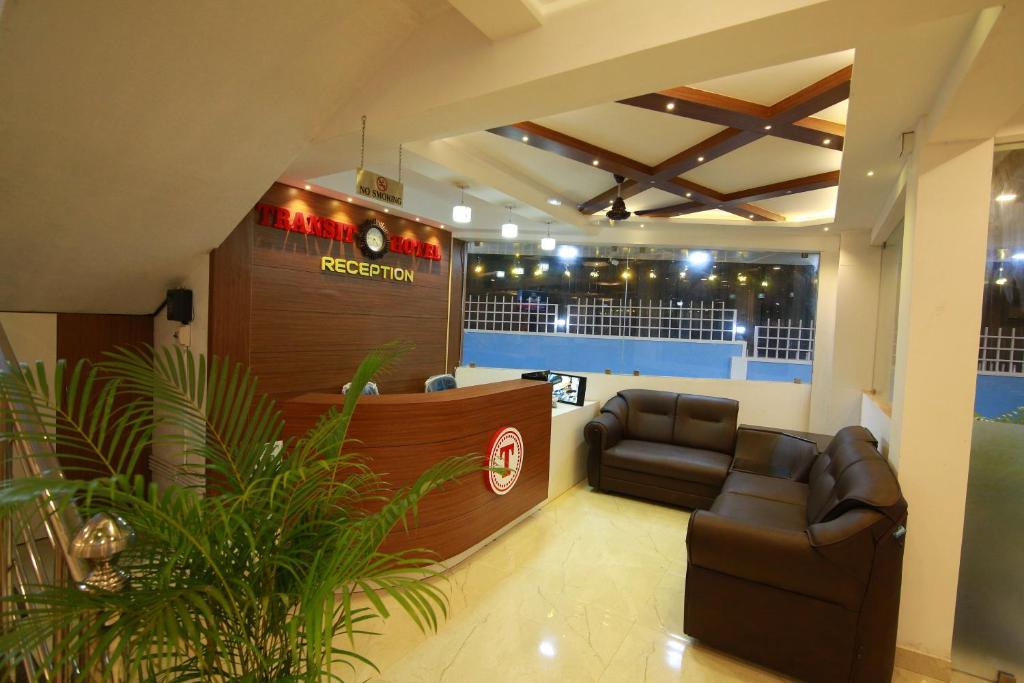 坎努尔Gateway Airport Hotel的一个带沙发的候客室和一个酒吧的沙龙