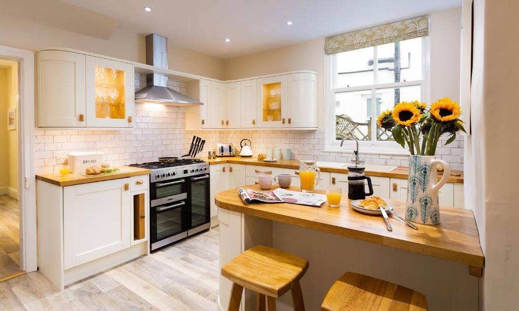 凯西克Brandelhow House的厨房配有白色橱柜和木制台面