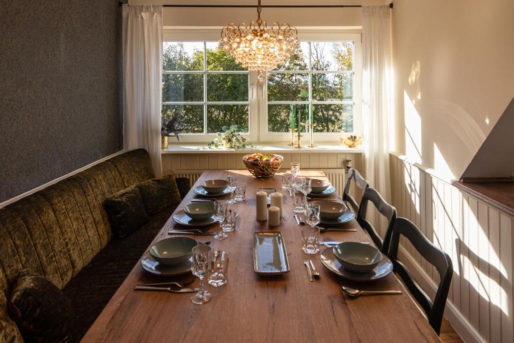 费马恩Henkieker - ländliche Ferienwohnung mit Stil的餐桌、椅子和吊灯