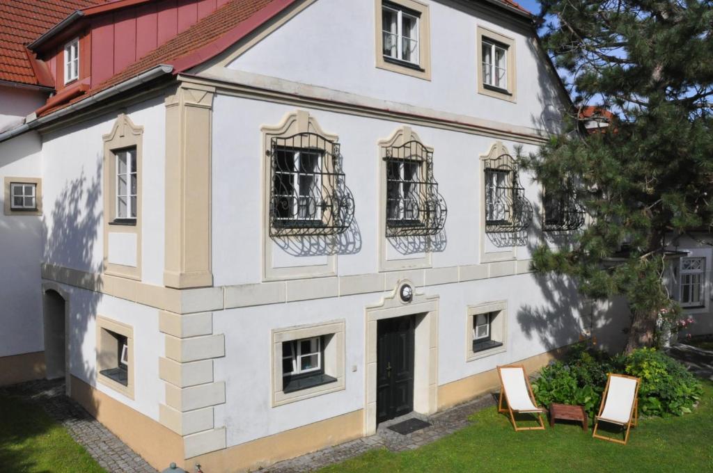 StiefernHaus Irblingweg的院子里的白色房子,带两把椅子