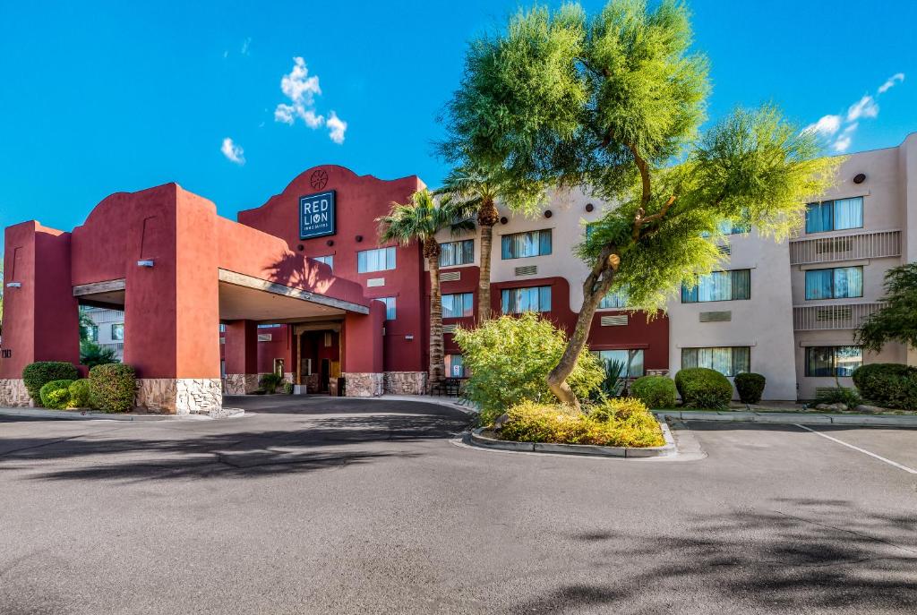 嘉年Red Lion Inn & Suites Goodyear的前面有棕榈树的建筑