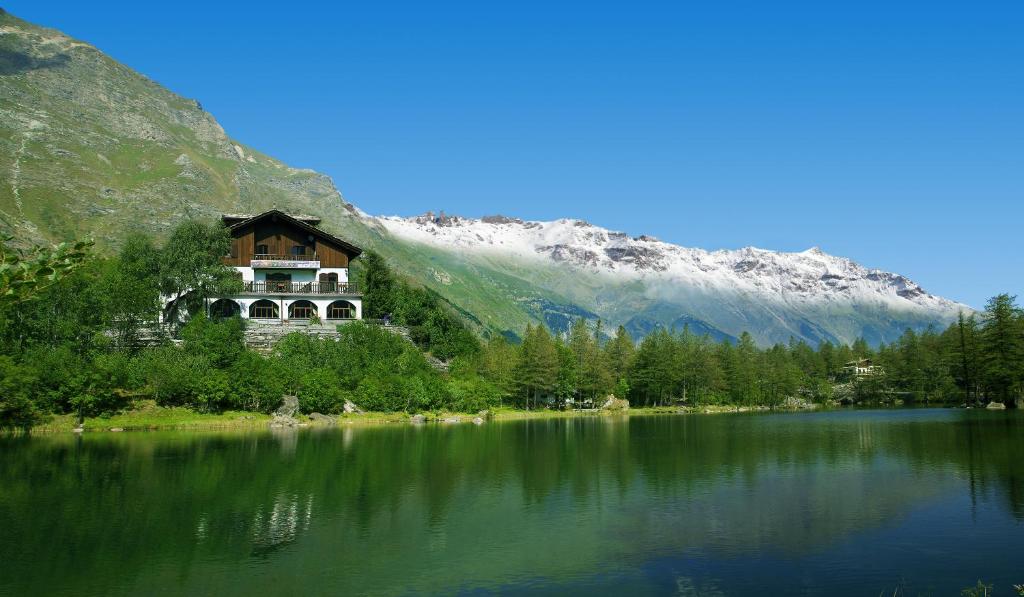 蒙切尼肖Chalet Sul Lago Hotel In Montagna的山前湖畔的房子