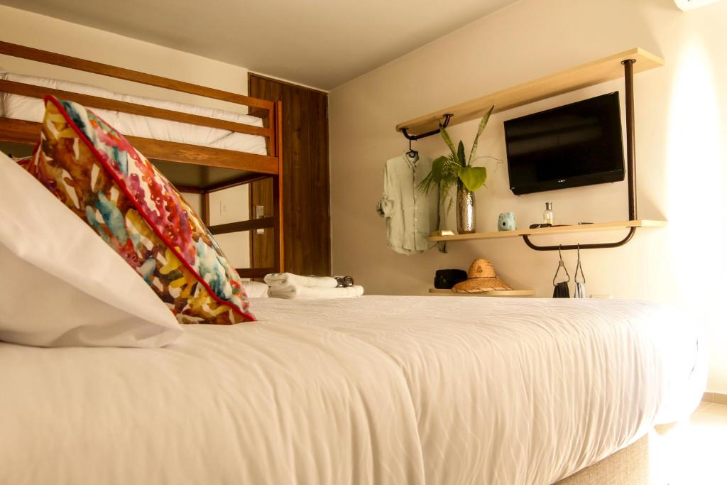 里奥阿查Hotel Tunebo Inn的卧室配有一张床铺,墙上配有电视