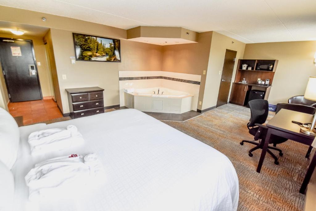 温尼伯Canad Inns Destination Centre Polo Park的酒店客房设有一张大床和一张书桌。