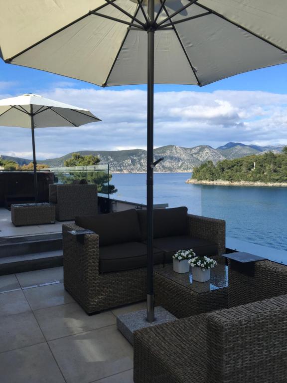 拉茨斯切High View-A Seaside Villa With Huge Jacuzzi的一个带沙发和遮阳伞的庭院