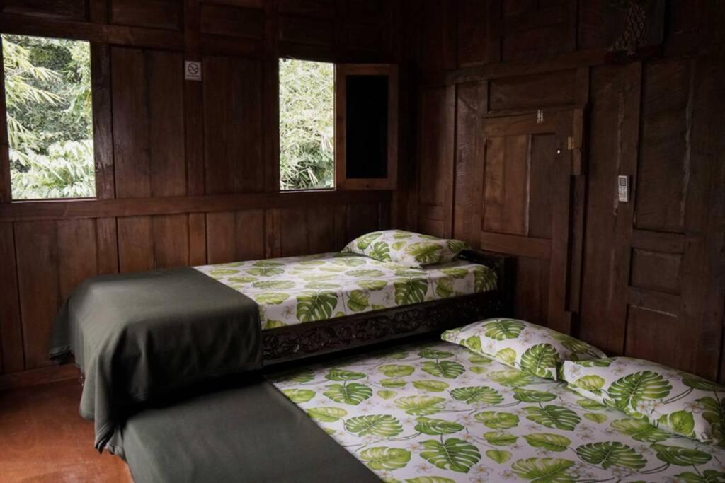 斯勒曼Rumah Kayu Joglo Yudhistira, tepi sungai, 2BR的带2扇窗户的客房内的2张床