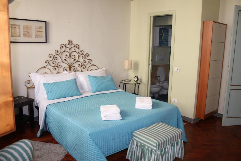 佛罗伦萨学院一室公寓酒店的一间卧室配有蓝色的床和2条毛巾