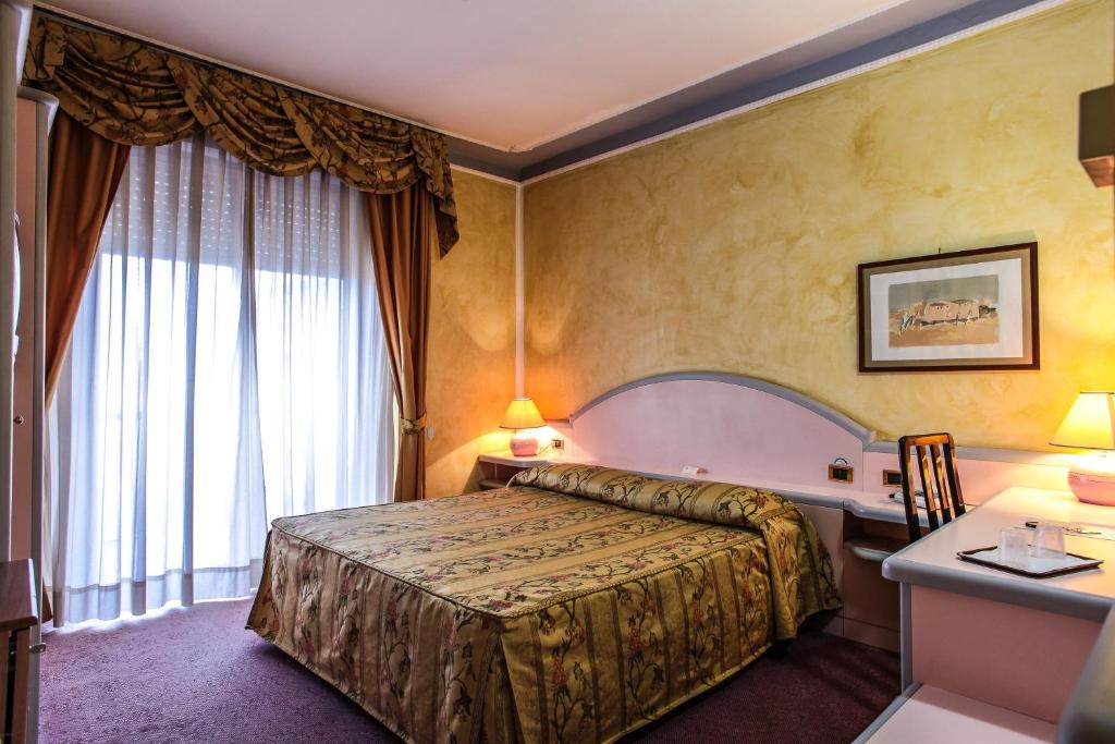 萨萨里格拉西阿德勒达酒店的配有一张床和一张书桌的酒店客房