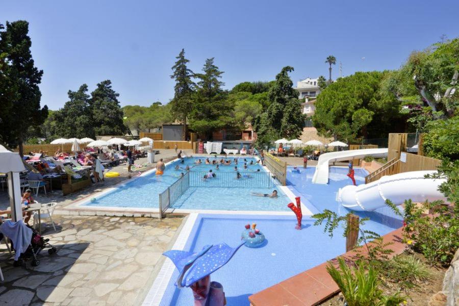 罗列特海岸Camping Sènia Cala Canyelles的一个大型游泳池,人们在里面玩耍