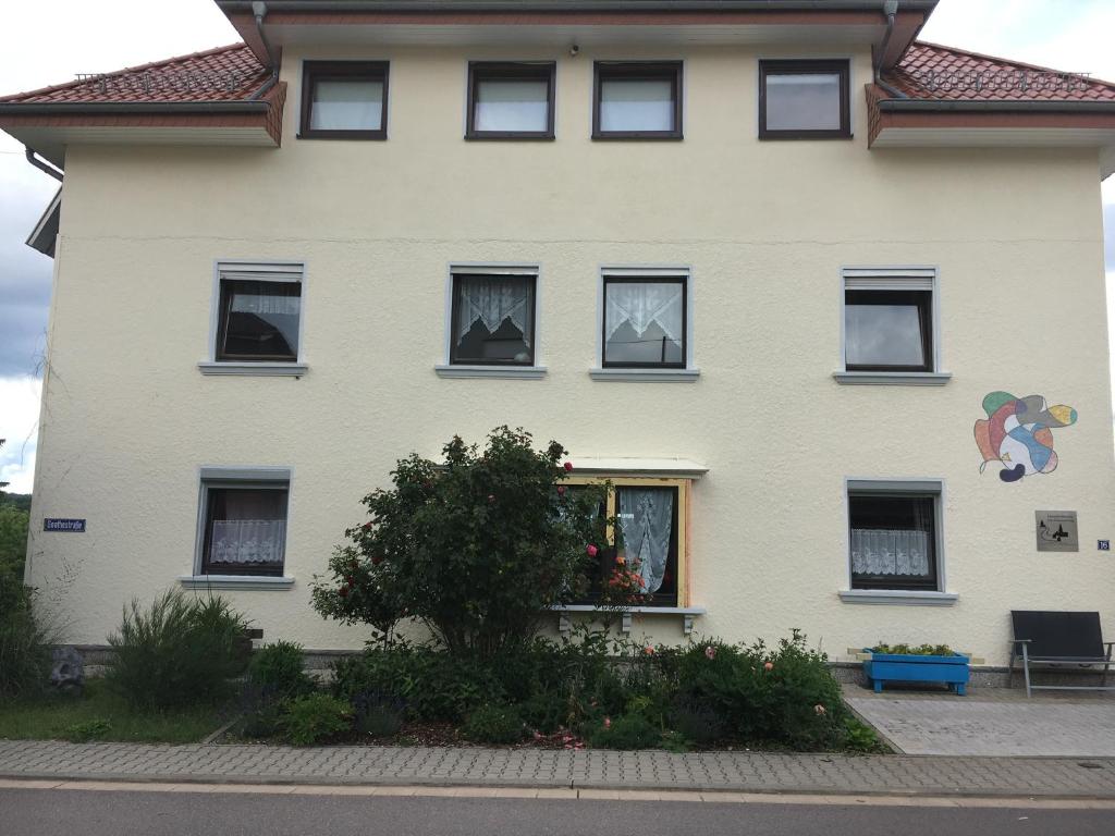 TholeyFerienwohnung Am Schaumberg的白色的房子,有黑窗和树