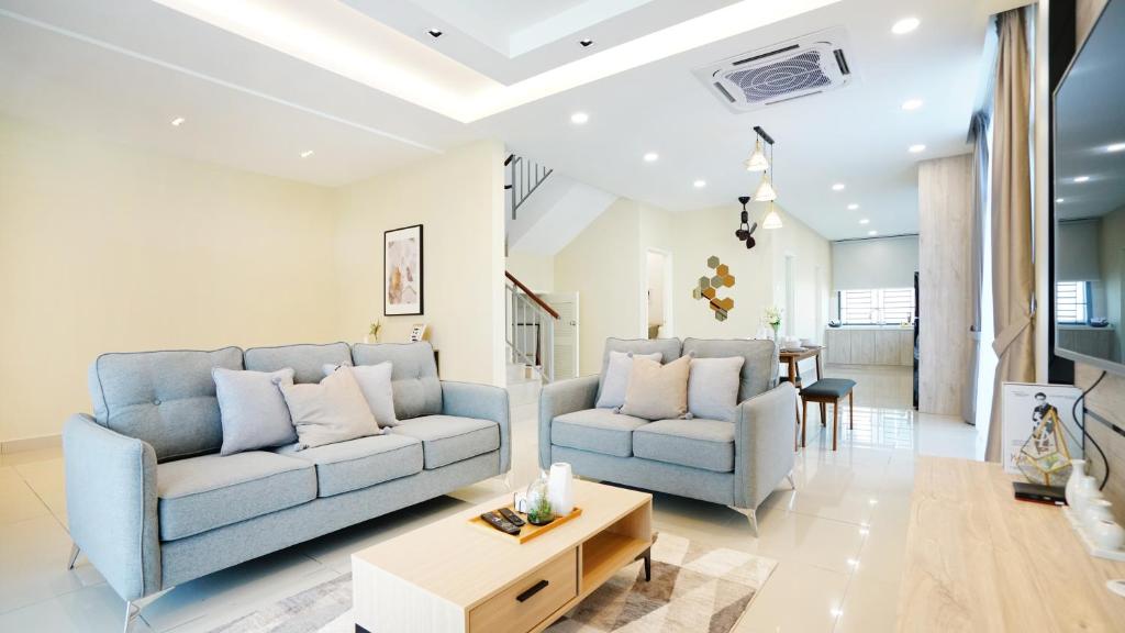 迪沙鲁Desaru Exclusive Elegant theme by Joyfully 2M8的客厅配有2张蓝色的沙发和1张桌子