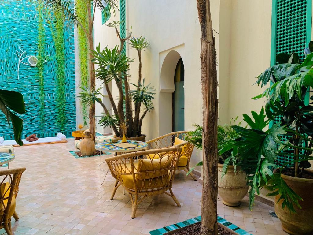 马拉喀什Riad Alia的大堂里种着许多植物和椅子