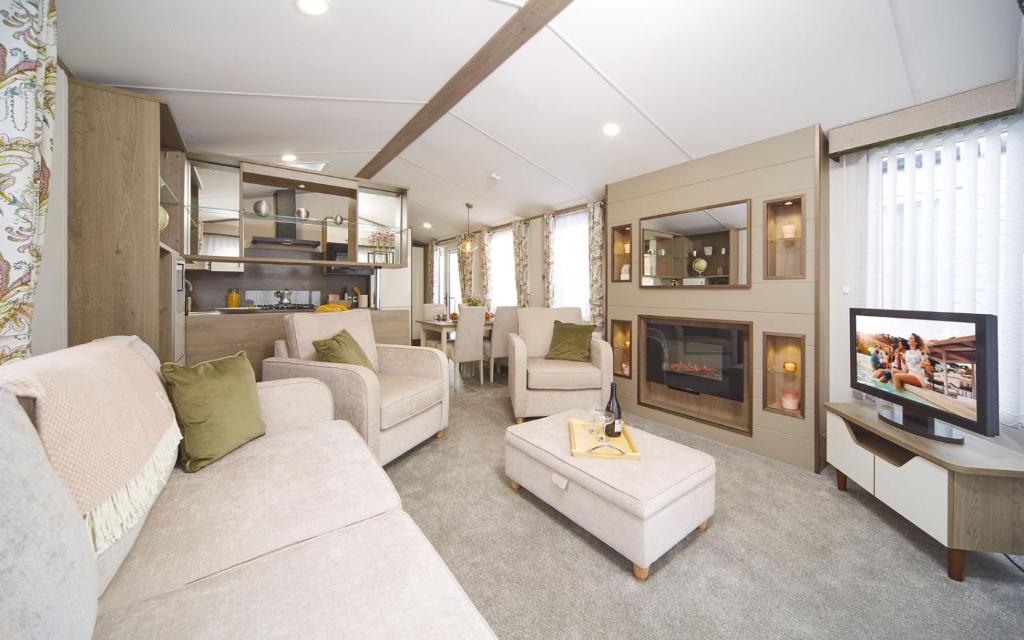 南塞尔尼Lavender Lodge的客厅配有2张白色沙发和电视